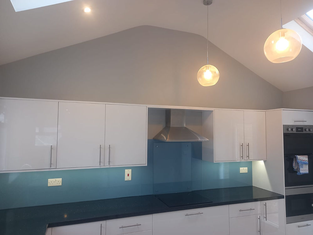 Modern kitchen with white cabinets and blue backsplash
