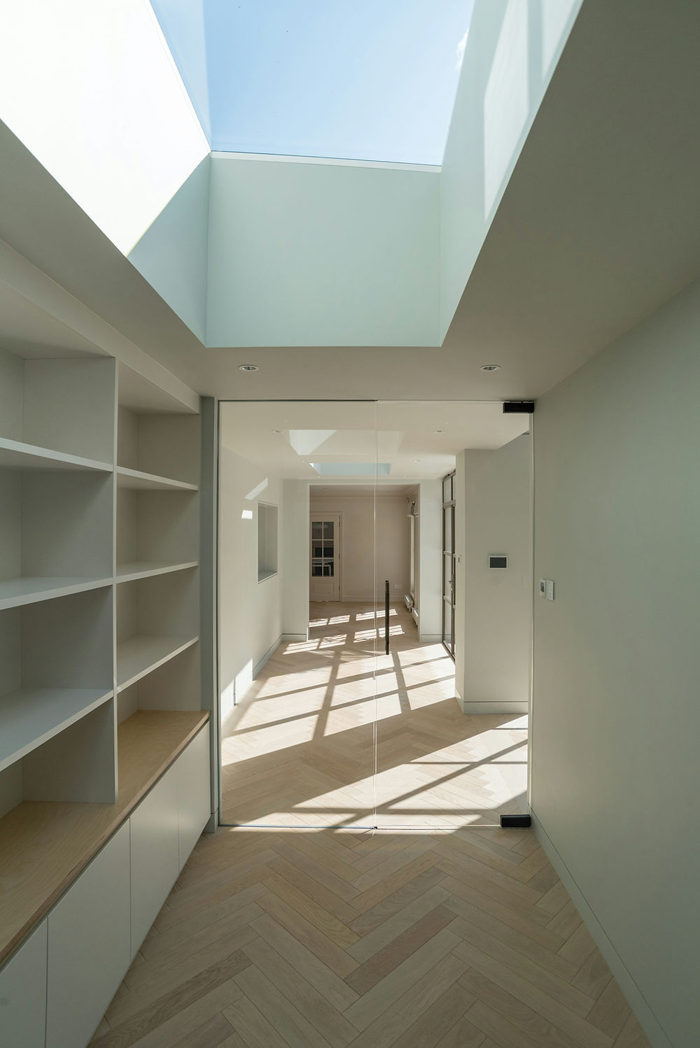 Modern interior hallway with skylight and built-in shelves