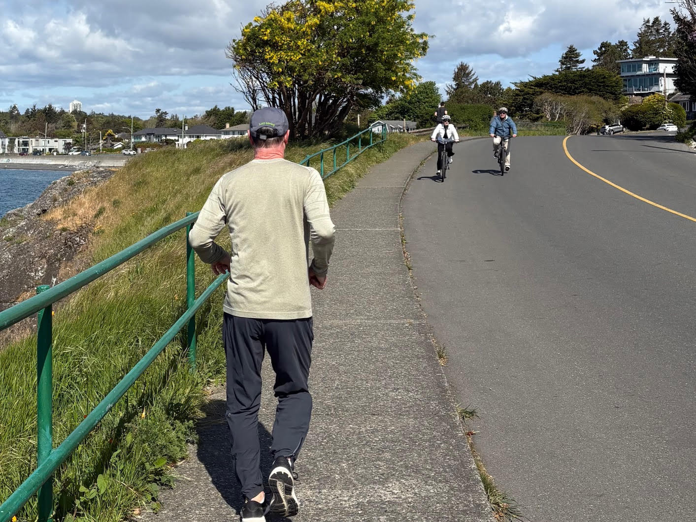 Man running from behind and two cyclists coming toward.