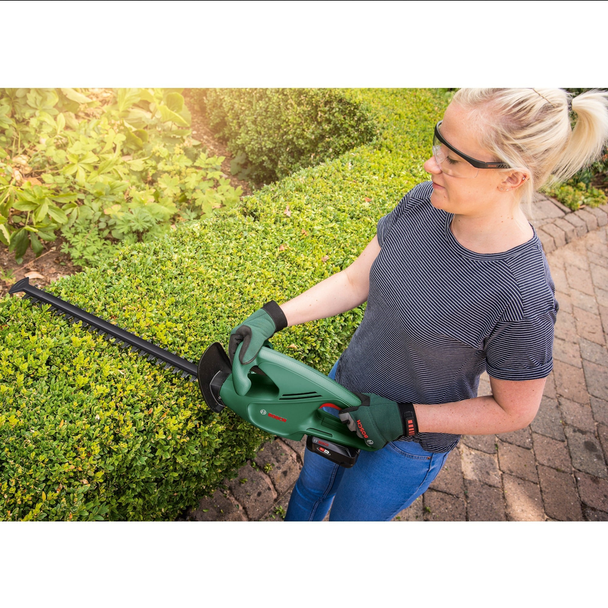 Miniature : Femme utilisant le Bosch EasyHedgeCut 18-45 sur une haie.