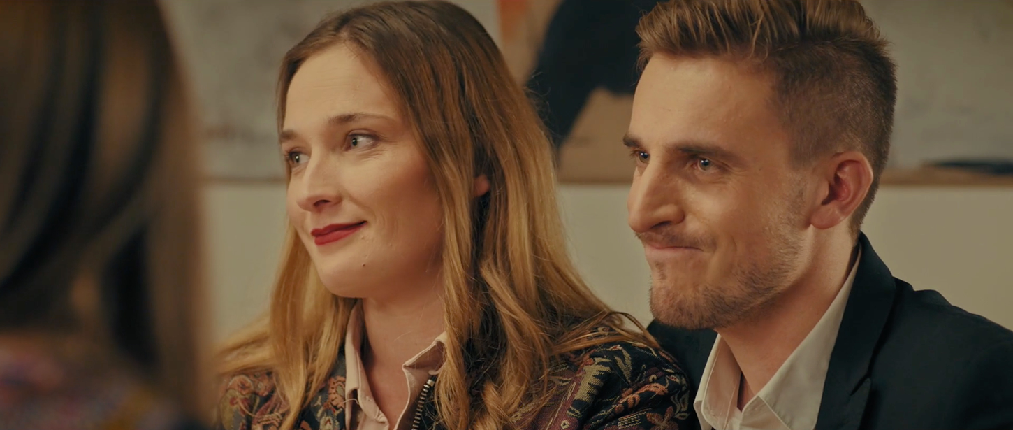 Un couple assis à table fait une moue.