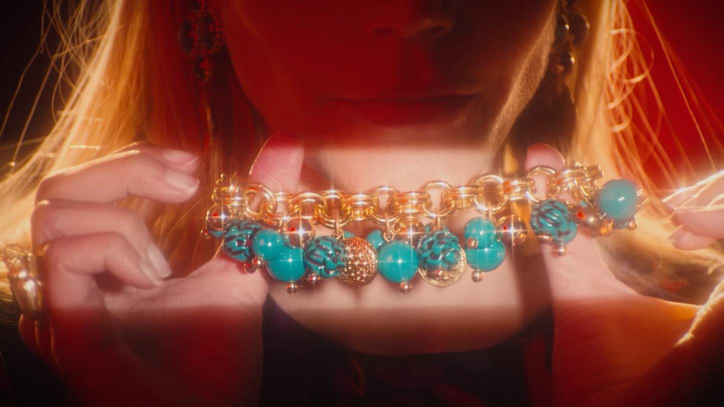 Une femme est traversé par un rayon de lumière qui révèle un collier brillant.