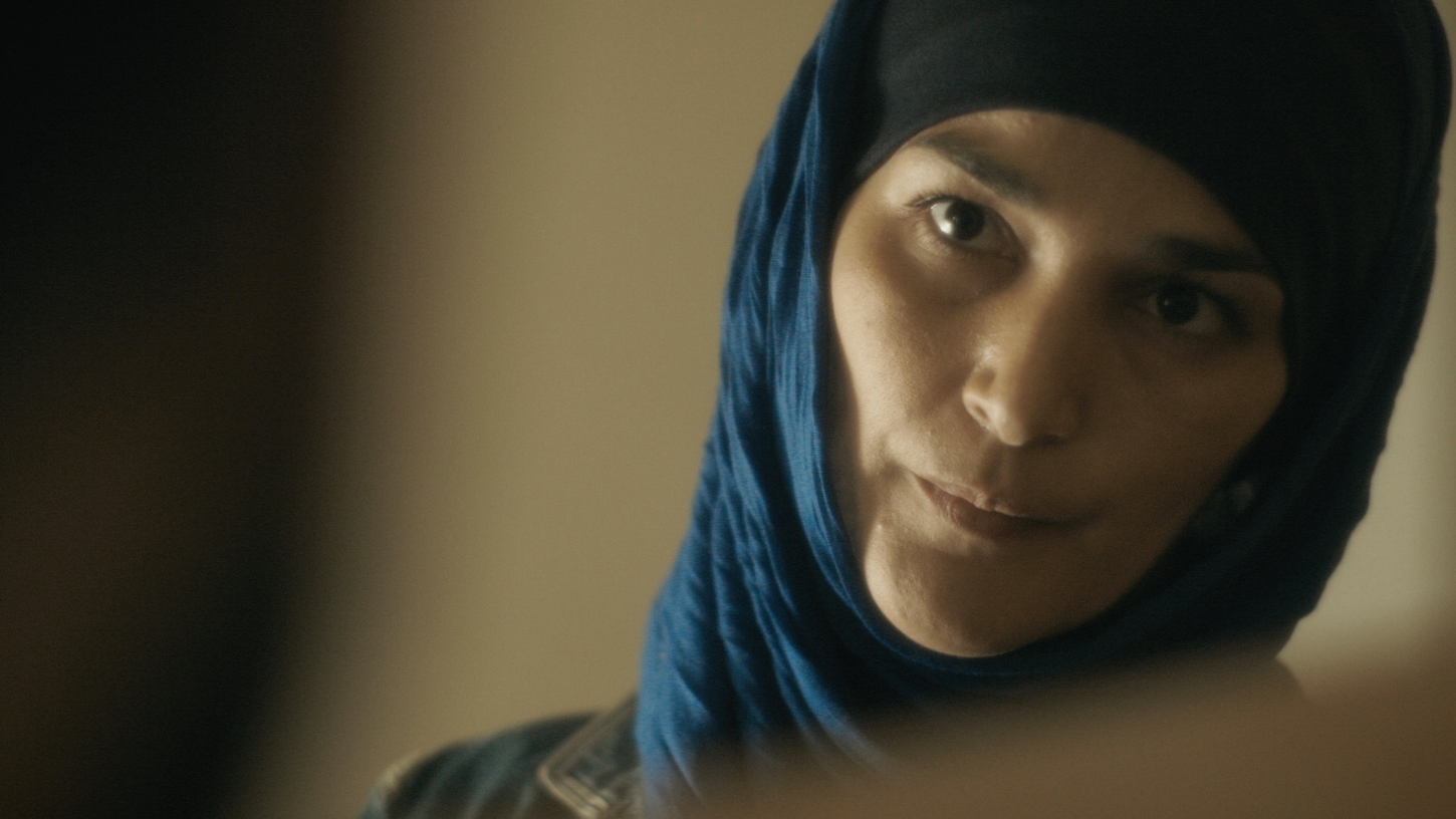 Une femme voilée regarde son mari.