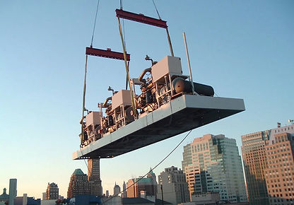 Three combined heat and pwoer units delivered to Macy's department store in Brooklyn. They are suspended by a crane.