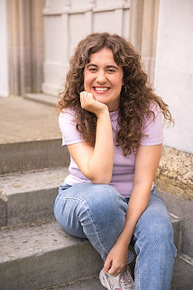 Porträt von Eliane Scherer, Coachin von shift.happens, lächelnd auf einer Treppe – warm, offen und einladend.