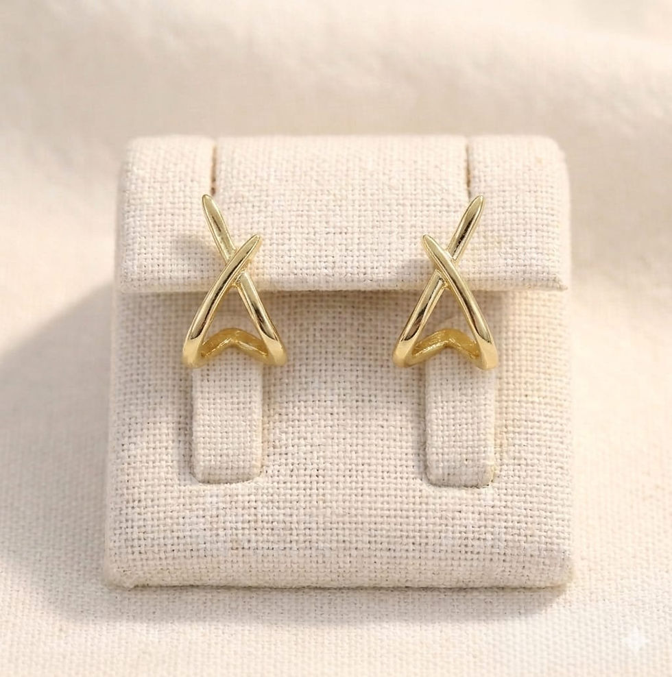The Clarity Solitaire gold crisscross earrings on a display stand