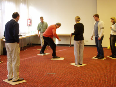 Indoor-Teamwork: Führungskräfte entwickeln Strategien zur Team Performance und stärken Füreinander-Kultur.