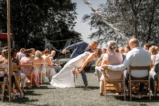 de bruid en bruidegom geven elkaar een kus na de ceremonie in het gangpad