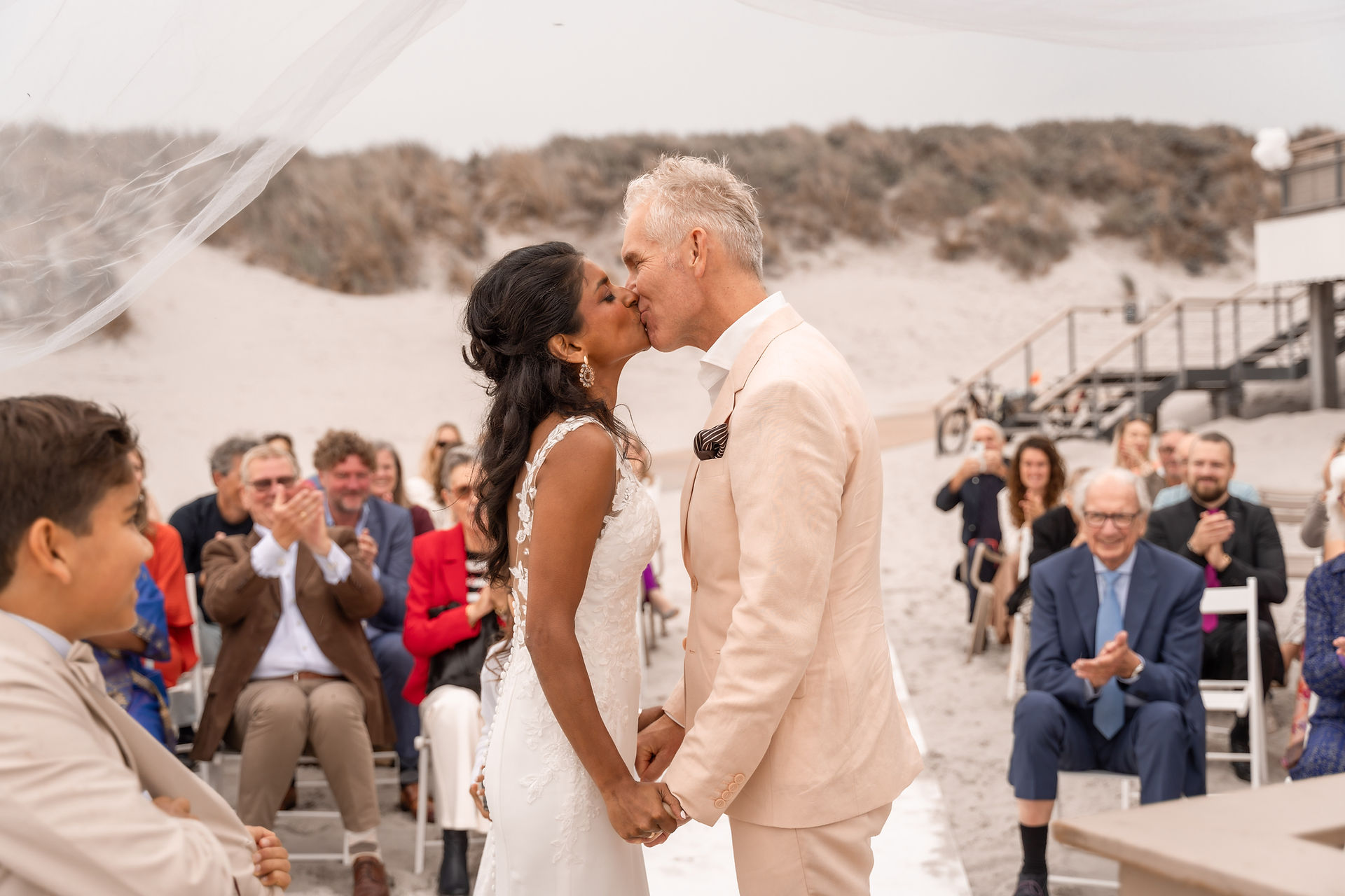 Intiem moment: het bruidspaar kust elkaar tijdens de strandceremonie op Ameland