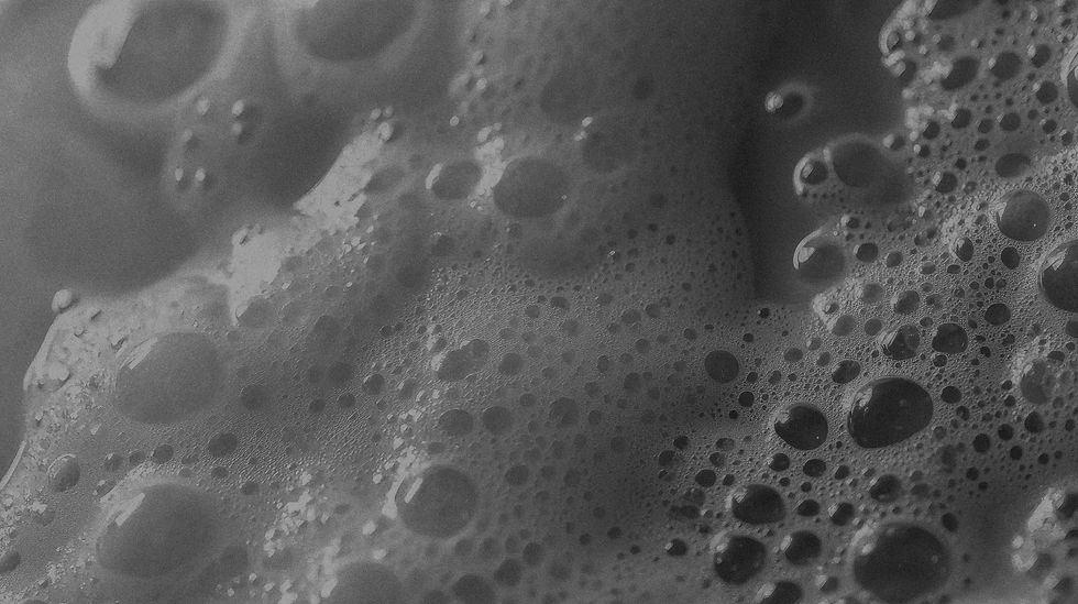 Close-up of frothy bubbles and foam texture, commonly associated with skincare cleansers or facial treatments, used as a background for aesthetics or wellness branding.