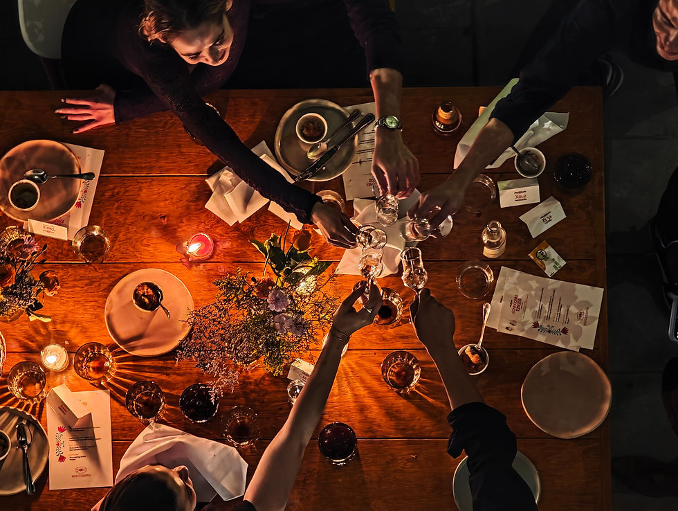 friends cheering at a table with food and mezcal in a beautiful set up at night