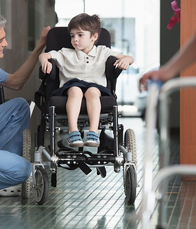 Doctor hablando con niño en silla de ruedas