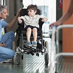 Doctor Talking to Boy in Wheelchair