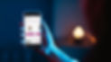 hand in blue light holding a cell phone
