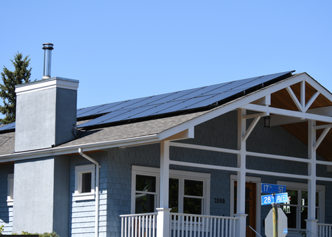 Solar panels on a roof of a blue house