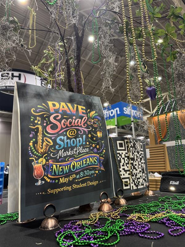 PAVE Social event sign with colorful text and musical motifs at New Orleans marketplace, beads hanging above; QR code beside it.