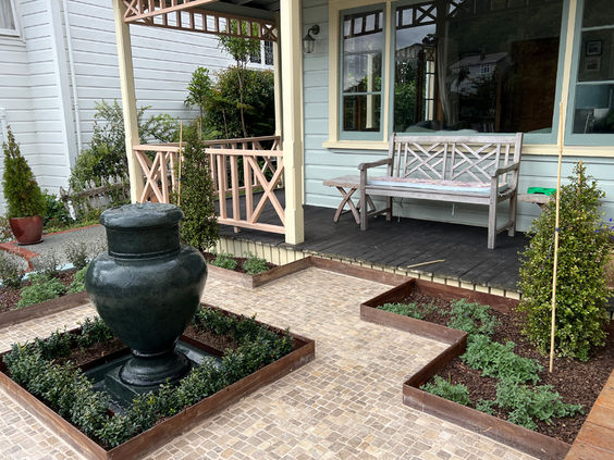 Formal garden surrounding fountain with steel garden edging