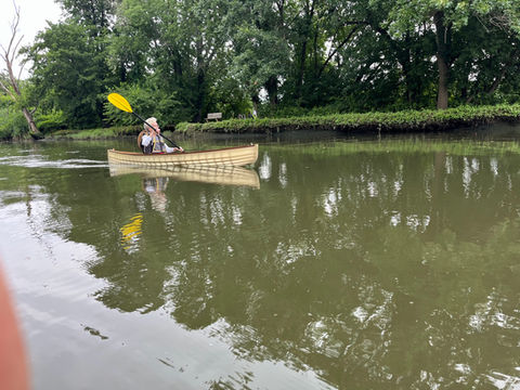 Woman paddling custom built canoe in lake