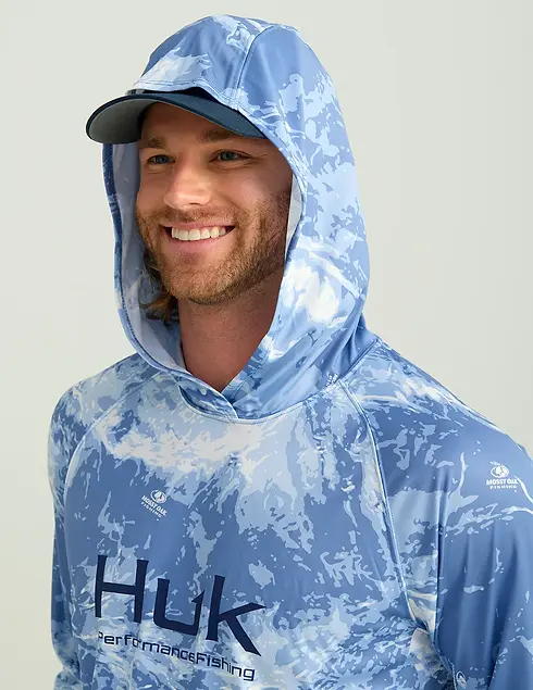 Smiling man wearing Huk Performance Fishing Hoodie