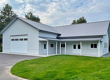 White industrial building with garage door and front porch, green lawn