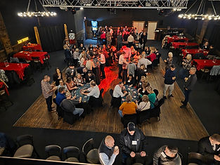 People gathering around casino tables at a social event.