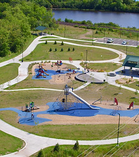 Aerial view of a community park with a playground and river