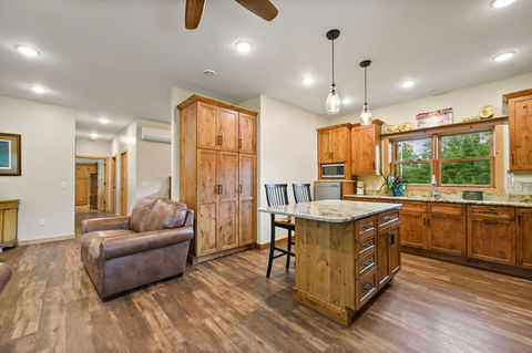 Custom features comprise detailed trims, cabinetry with quartz countertops, and beautiful wood flooring throughout.