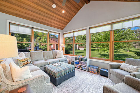Custom home build featuring barn wood tongue & groove, timber beams, cabinetry, siding, trim, fireplace, and detailed timber frame entry in the interior design.