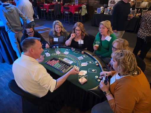 People enjoying a card game at a Vegas Night event table.