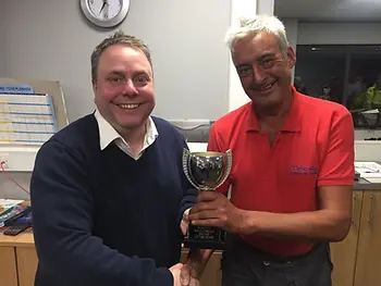 Two men standing with trophy