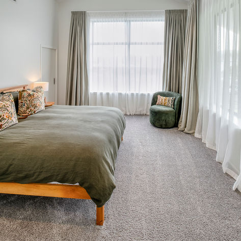 Modern bedroom with green bed and carpet flooring