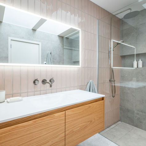 Modern bathroom with wood vanity and lit mirror