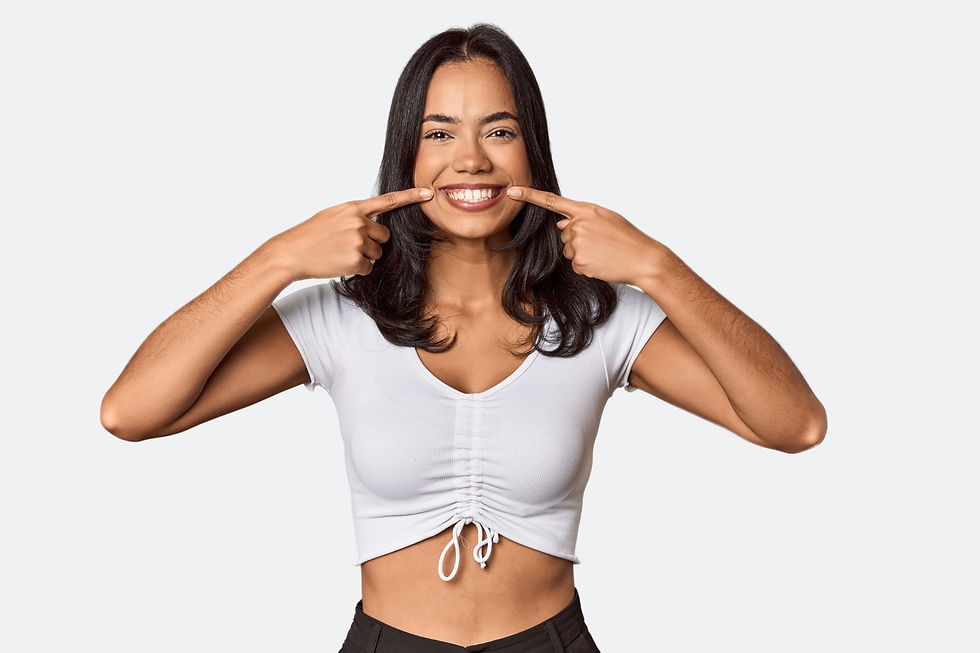 Young filipino woman smiles, pointing fingers at mouth..jpg