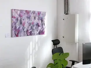Abstract purple painting exhibits in a bright office space.