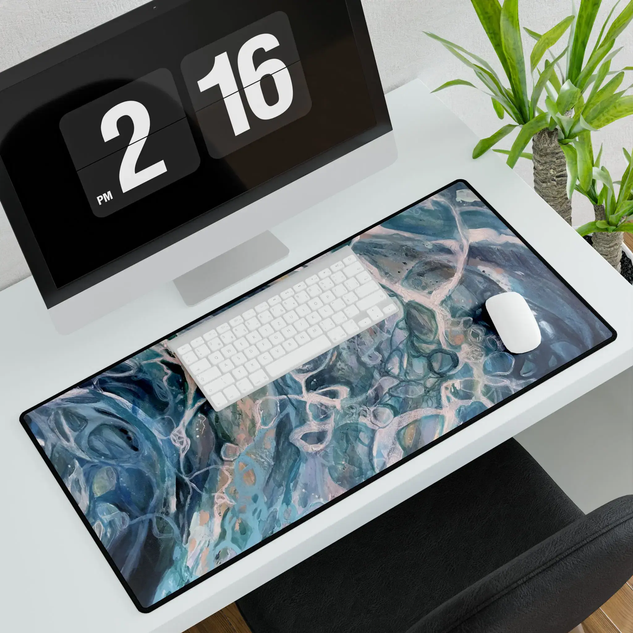 Desk setup with abstract blue mouse pad, keyboard, monitor