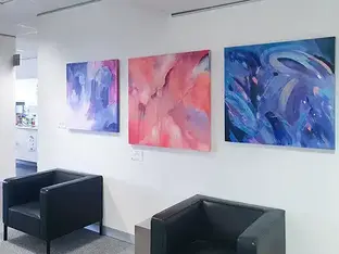 Abstract painting exhibits on a white gallery wall.