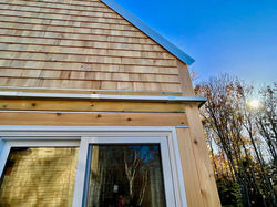 Close-up view of the cedar shingles and large windows of TwoBySea cottage