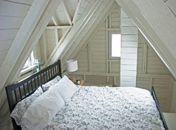 different view of Queen bed in the loft bedroom area at deepBlueSea cottage
