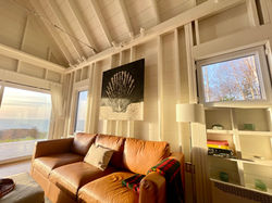 comfortable leather couch in the afternoon light at TwoBySea cottage