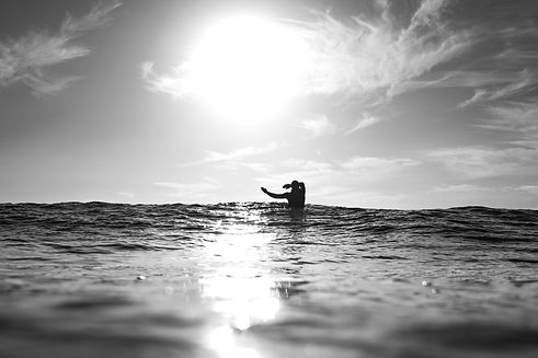 un surfeur au milieu de la mer de la manche avec le reflet du soleil