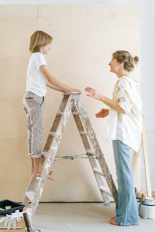 A mom and child painting a wall