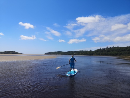 paddle boarder on calm estuary