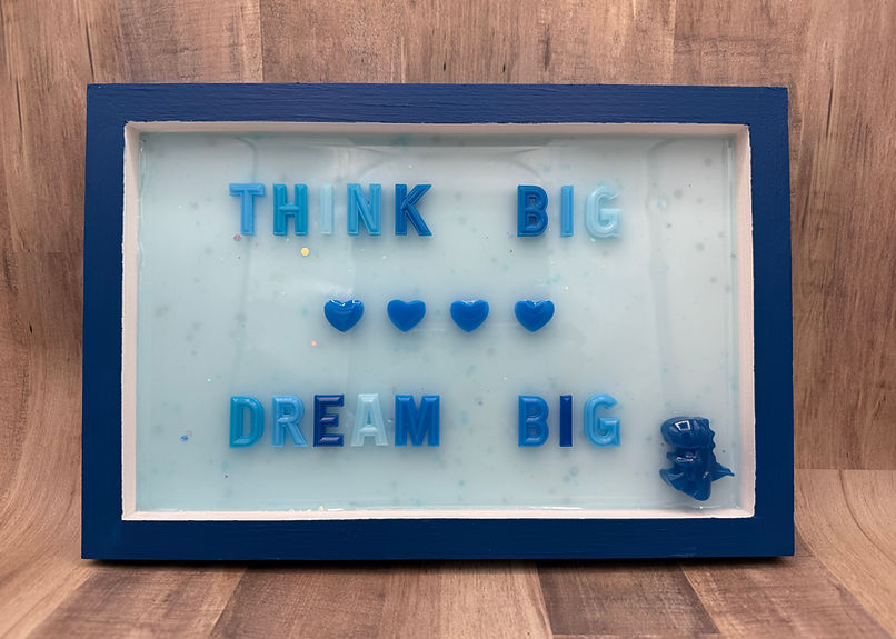 Think Big Dream Big, inspirational quote in blue resin, with a blue dinosaur and nighttime confetti