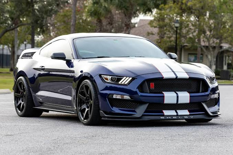 Blue Shelby Mustang with white stripes parked in a lot, modern American performance car, landscape, blue and white tones.