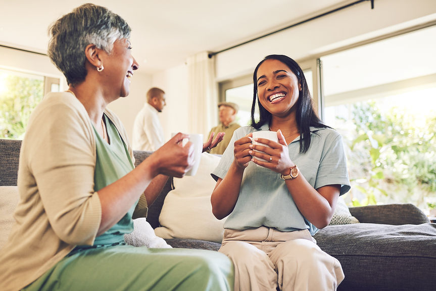woman-drinking-cup-coffee-with-her-senior-mother-while-laughing-talking-bonding-home-happy