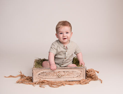 Photo of baby boy sitting in shabby chic drawer on green wool stuffer wearing pale green romber by Hull and East Yorkshire, Baby and Toddler Photographer