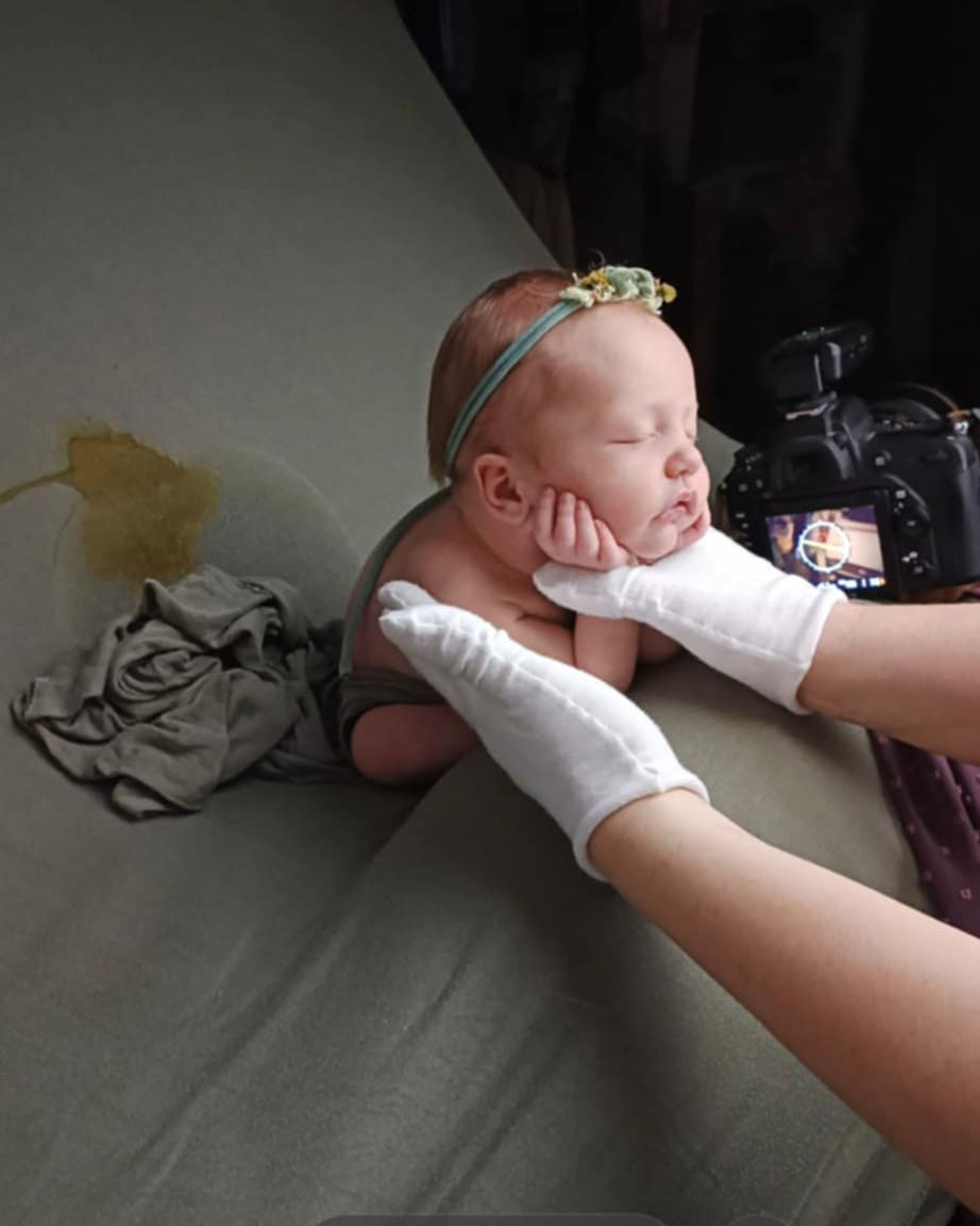 Behind the scenes photo of Leonie Newborn Photographer in Hull working with baby girl supporting for froggy pose