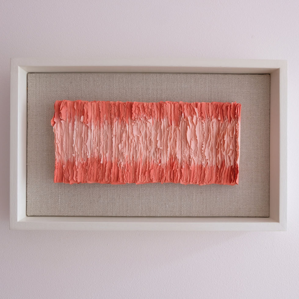 A framed ceramic maquette is two tone with pink and red