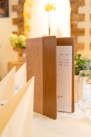 Geöffnete Speisekarte aus Holz auf einem gedeckten Tisch im Gasthaus Kaiser in der Gaal