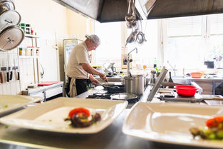 Koch bei der Essenszubereitung in einer Profiküche im Gasthaus Kaiser in der Gaal